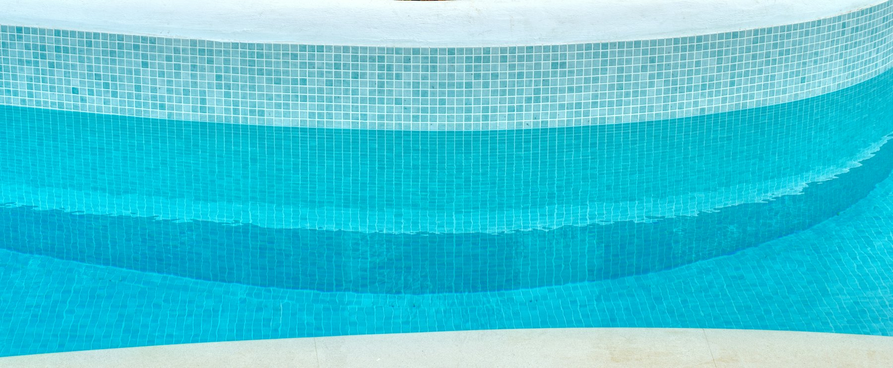 Close view of smooth blue pool finish and tiled steps